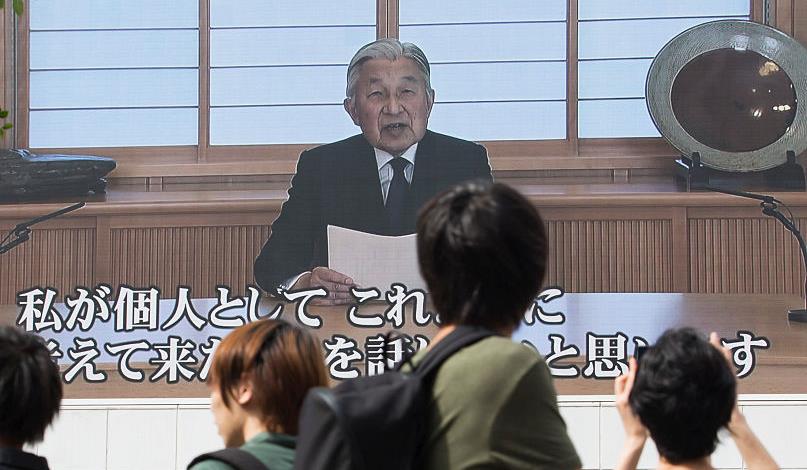 Pedestrians in Tokyo watch a monitor showing Emperor Akihito delivering a video message on August 8, 2016. © Tomohiro Ohsumi/Getty Images